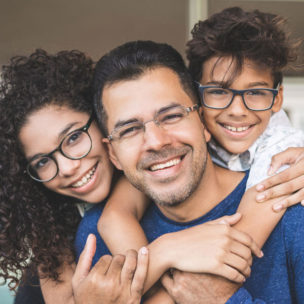 father, daughter, and son embracing on front porch