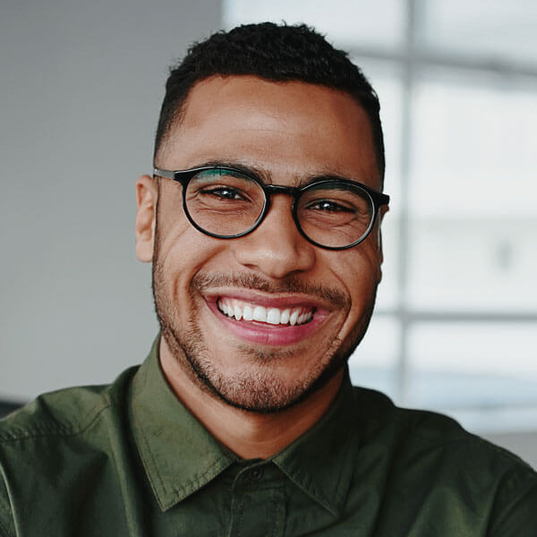 smiling, confident, young businessman standing with his arms crossed looking at camera